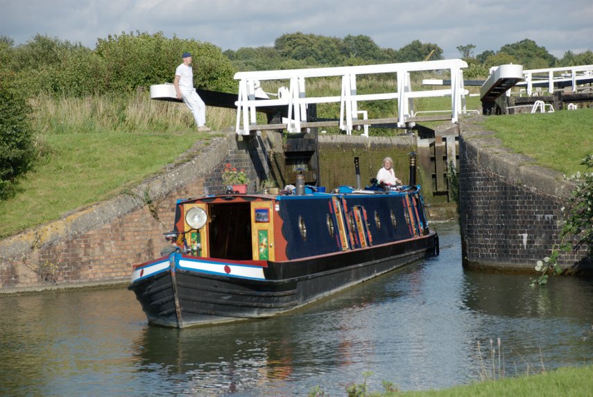 A Narrowboat emerging from a lock, Caen Hill Locks, Rowde, Devizes, Wiltshire, England, Great Britain